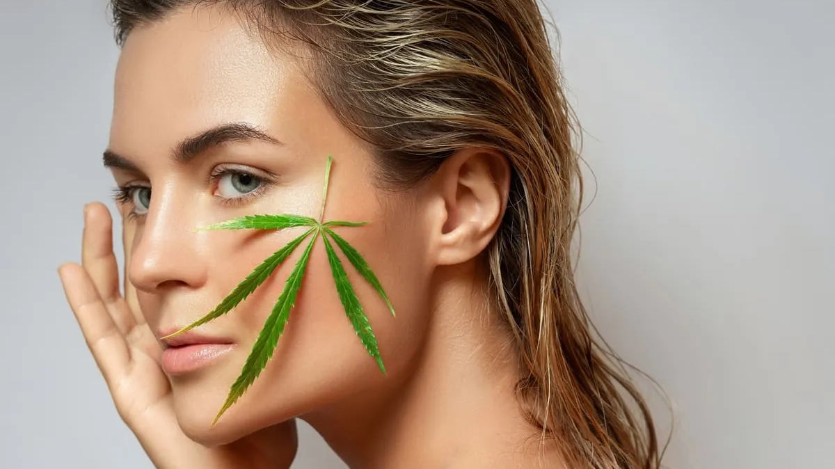 Une femme avec une feuille de cannabis CBD sur la peau, symbolisant les bienfaits du CBD pour la peau.