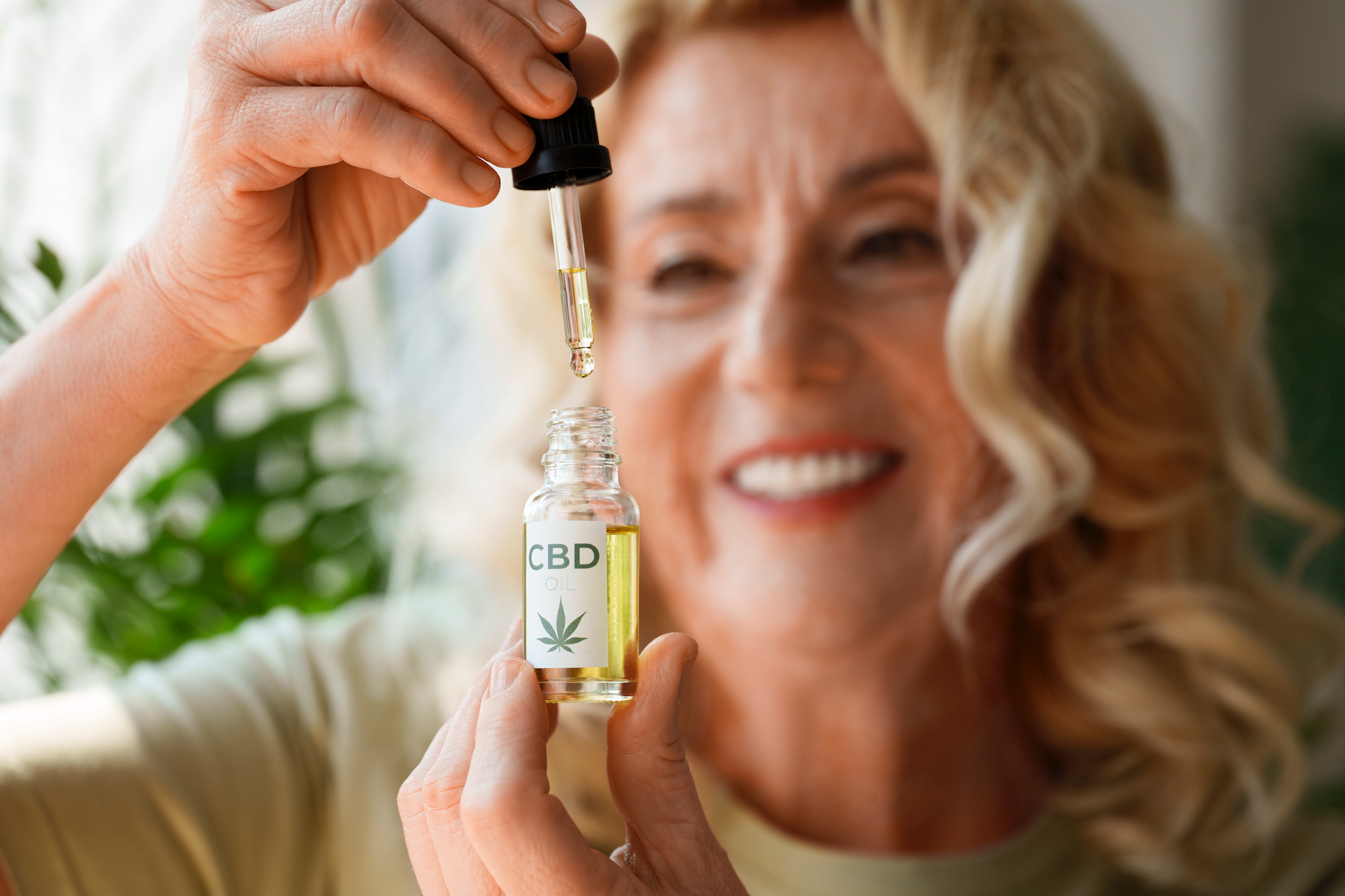 femme heureuse prenant une pipette de cbd